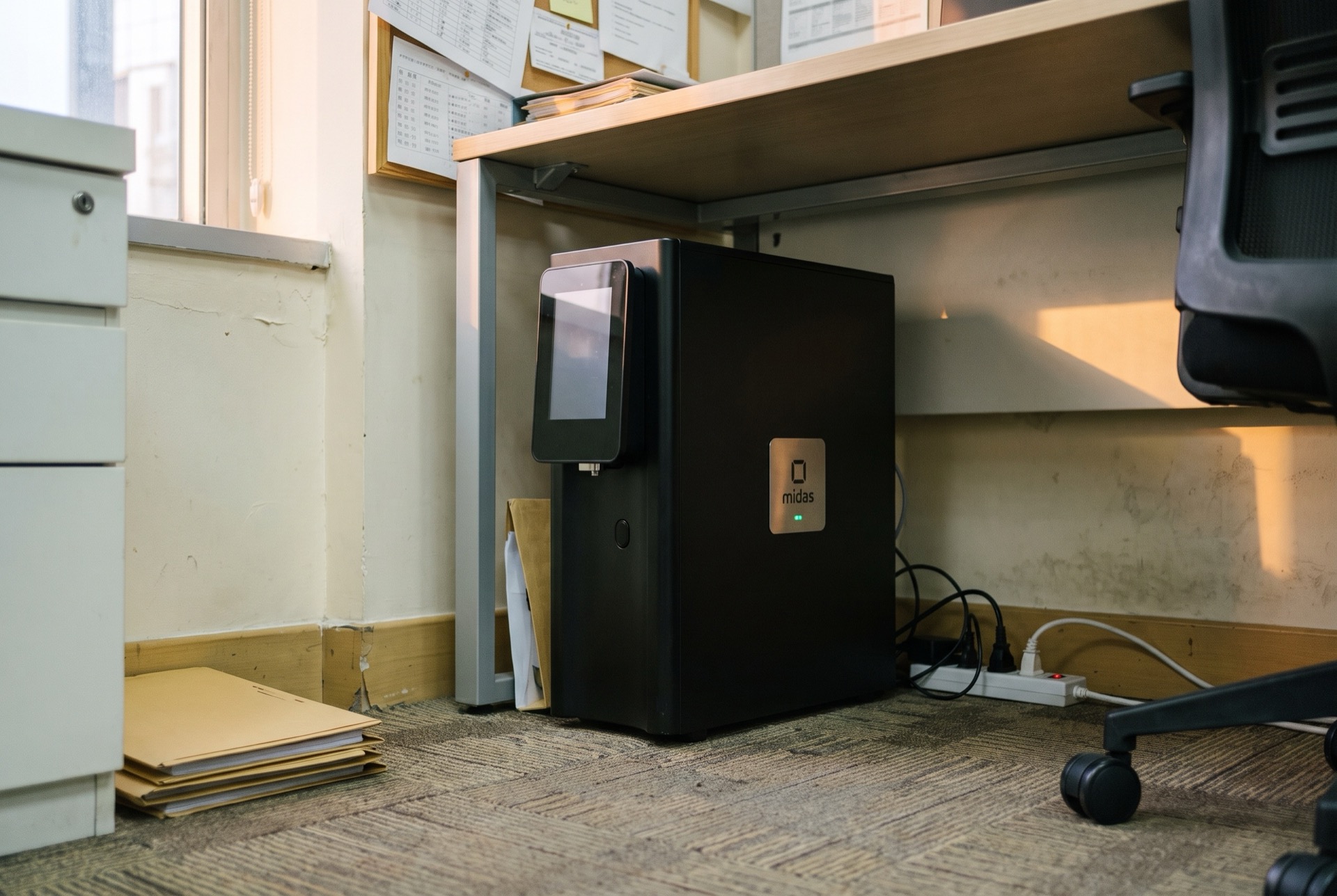 The appliance under a desk in a Hong Kong office — power and network cable, shot as found